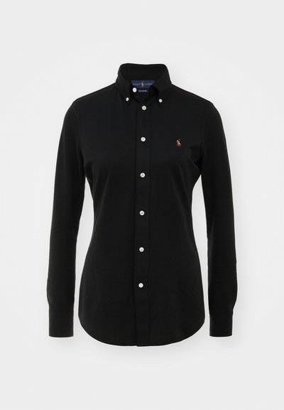 Černá košile s dlouhými rukávy vyrobená z bavlny, s límečkem na knoflíky, bílými knoflíky a malým vyšitým logem na hrudi.