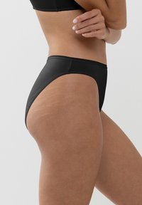 Zwarte bikini onderkant met een hoogbroek ontwerp. Glad stof, minimale stiksels en een klassieke afwerking. Benadrukt een getailleerde silhouet.