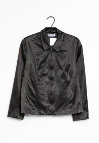 Svart satinjacka med dragkedja och krage, hängande på en svart galge mot vit bakgrund, som visar framifrån och långärmad.