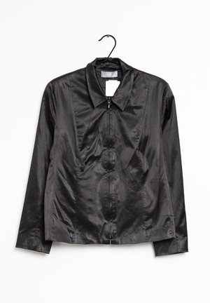 Zwarte satijnen ritsjack met kraag, hangend aan een zwarte hanger tegen een witte achtergrond, met een weergave van de voorkant en lange mouwen.