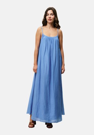 Maxikleid aus lichtblauem Stoff, mit schmalen Trägern, gerafftem Ausschnitt und fließender Silhouette bis zur Knöchelhöhe. Glatte, leichte Textur.
