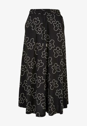 Gonna nera con motivo floreale, caratterizzata da fiori bianchi contornati, realizzata in tessuto leggero, con vita elastica e cordoncino regolabile.