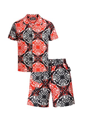 Completo abbinato composto da camicia a maniche corte con bottoni e pantaloncini con motivo circolare e floreale intricato nei colori rosso, nero e bianco.