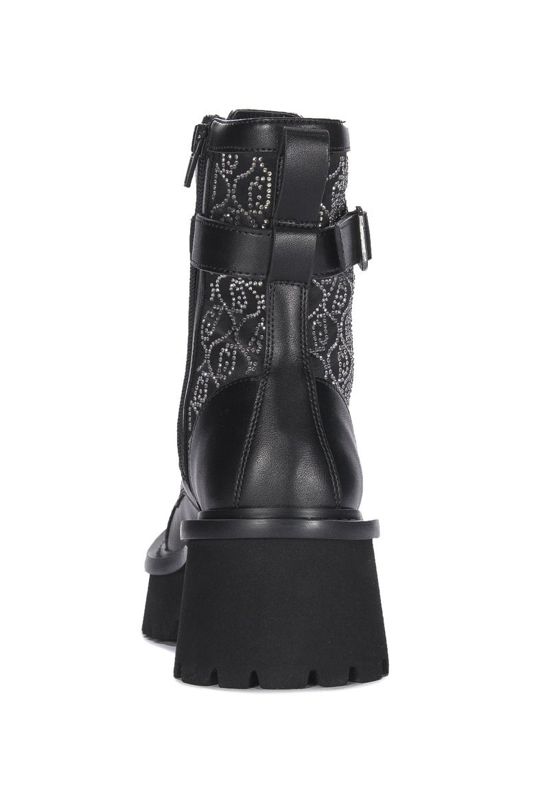 Bottines noires avec une tige en tissu texturé présentant un motif décoratif, une fermeture à glissière sur le côté et une semelle plateforme épaisse noire.