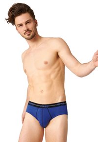 Culotte bleue en coton avec une ceinture noir contrastante, arborant un logo. Le tissu semble lisse et extensible, conçu pour le confort.