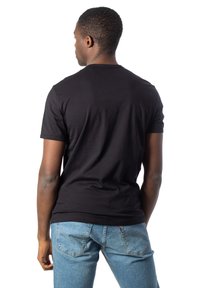 Svart bomull t-skjorte med korte ermer og rund hals, kombinert med lyseblå denimjeans med baklommer.