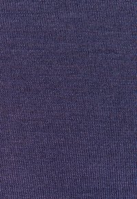Gros plan d’un tissu tricoté violet montrant des mailles serrées et uniformes ainsi qu’une texture tissée.