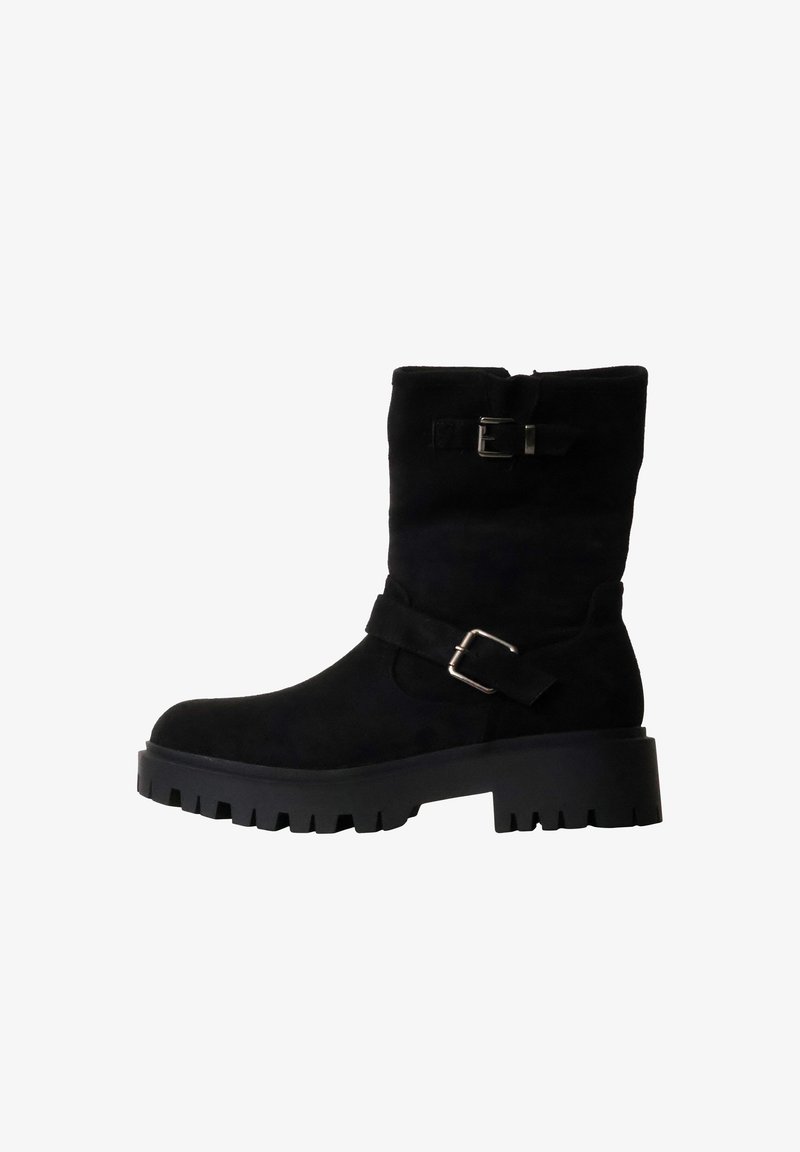 Botte noire mi-mollet avec semelle épaisse à crampons, bout rond, et deux boucles argentées réglables sur la tige et les sangles de cheville.