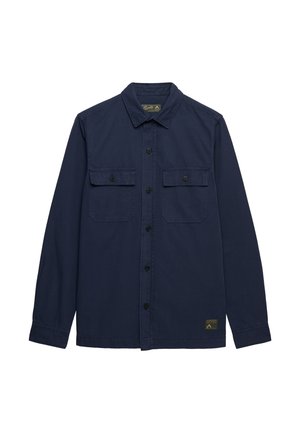 Camisa de manga larga azul marino con cuello, dos bolsillos en el pecho con botones y una pequeña etiqueta de tela cerca del dobladillo.