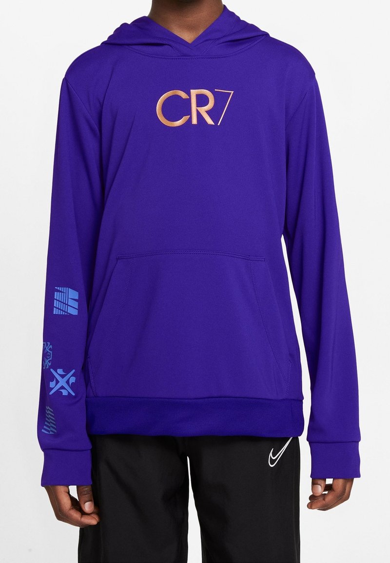 Sudadera con capucha morada y un logo dorado "CR7", con bolsillo frontal y patrones gráficos azules en las mangas. Elaborada con una tela suave y ligera.