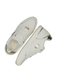 Sneaker bianche in tela con una parte superiore testurizzata, dettagli dorati e un medaglione con logo. Presentano lacci e una suola spessa in gomma per il supporto.