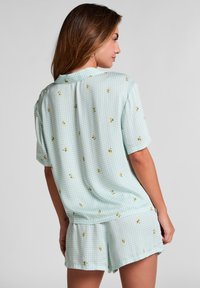 Korte mouw pyjama set in een lichtgroen ruitpatroon, met gele bloemaccenten, met een ontspannen pasvorm en zachte stof.