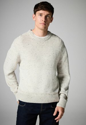 Textured cream sweater with a round neckline, ribbed cuffs, and hem. Features horizontal stripes and speckled detailing throughout.