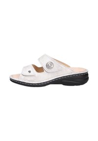 Open-toed sandal in textured white material with contrasting black sole. Features two adjustable straps and circular silver accent.
