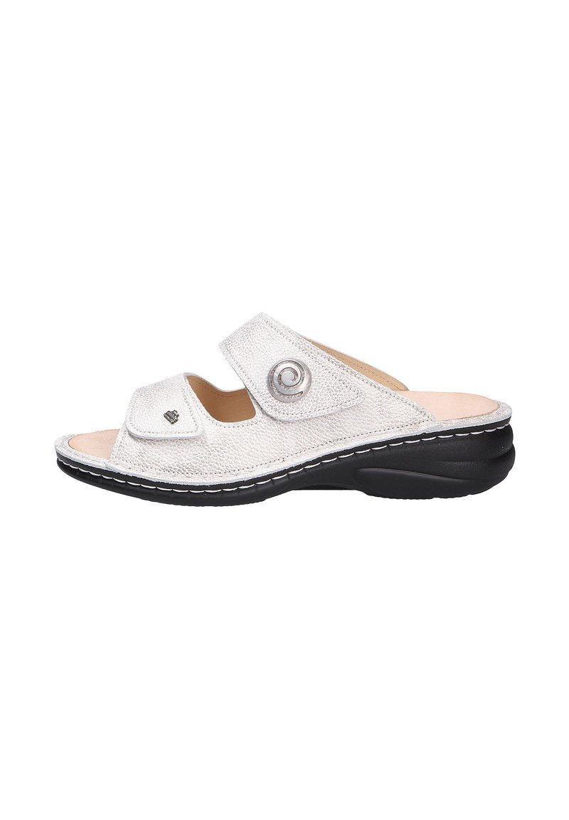 Open-toed sandal in textured white material with contrasting black sole. Features two adjustable straps and circular silver accent.