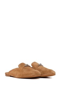 Paire de chaussures mules en daim marron à enfiler avec détail de boucle en métal sur le dessus, semelle plate, présentée sur fond blanc.