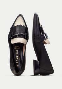 Schwarze Leder Schuhe mit spitzer Zehenform, versehen mit einer cremefarbenen Vorderseite und einem dekorativen schwarzen Riemen. Gestapelter Blockabsatz.