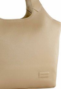Borsa tote in pelle beige con finitura testurizzata, dotata di un'ampia apertura, manico corto e logo impresso su un'etichetta rettangolare.