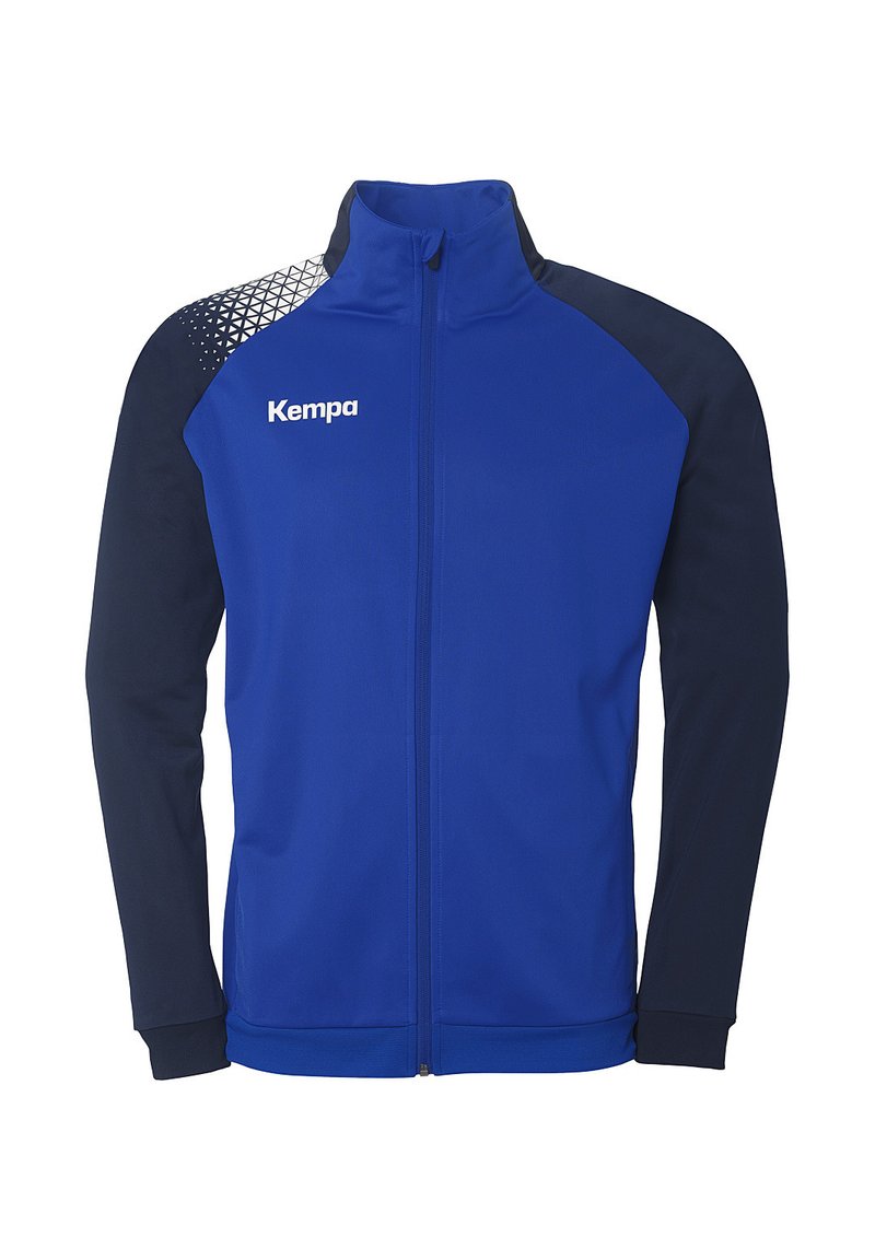 Blå atletisk jakke med marineblå accenter, fuld lynlås foran, høj krave og geometrisk mønster på den ene skulder. Har "Kempa" logo på brystet.