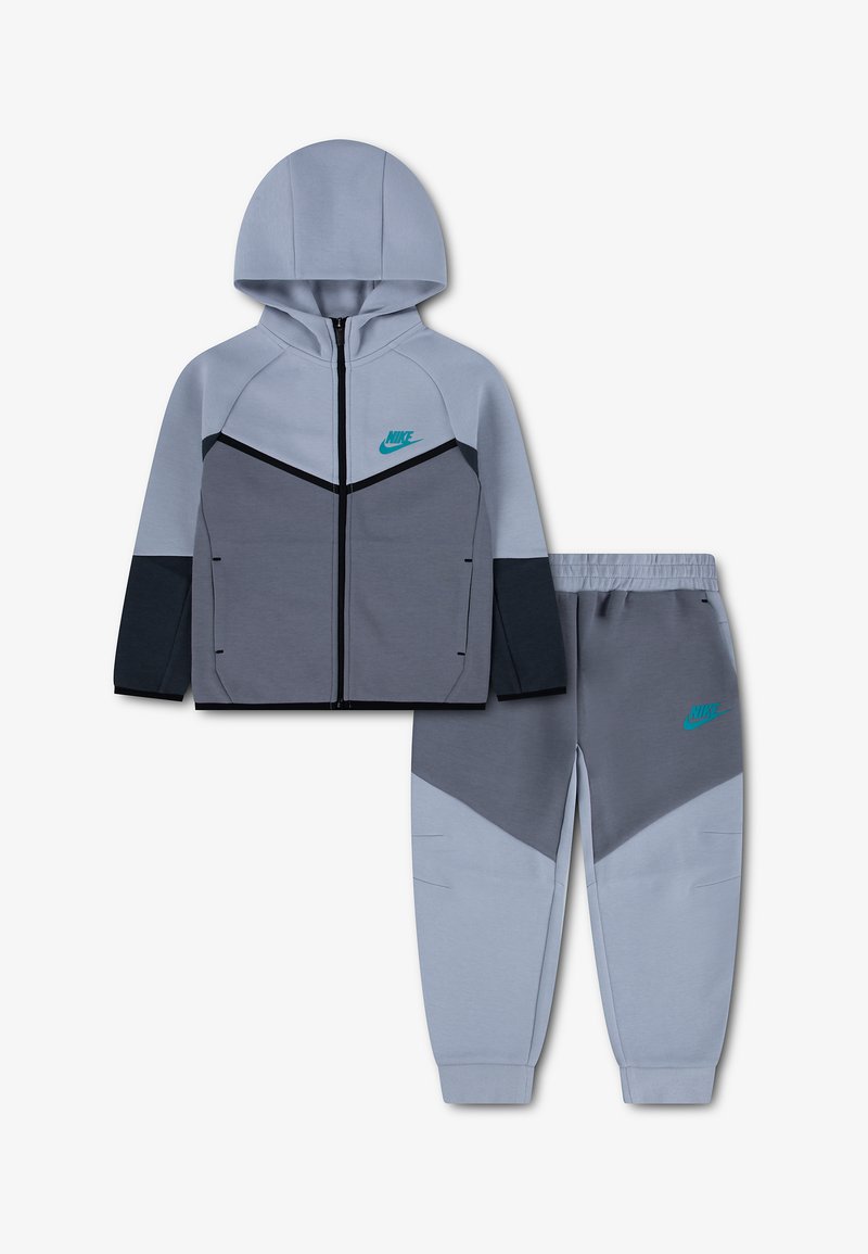 Двукомплектен спортен екип Nike с цип и качулка и панталони с еластична талия в светлосив, тъмносив и черен цвят с тюркоазени лога.