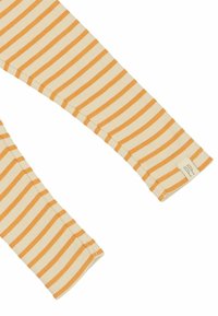 Prúžkované rukávy svetra v krémovej a oranžovej farbe. Hrejivá textúra, s tkanou nálepkou s iniciálami na manžete.