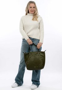 Sac fourre-tout en cuir vert olive avec deux poignées noires robustes, au toucher lisse et au design minimaliste. Présente un logo discret en bas.