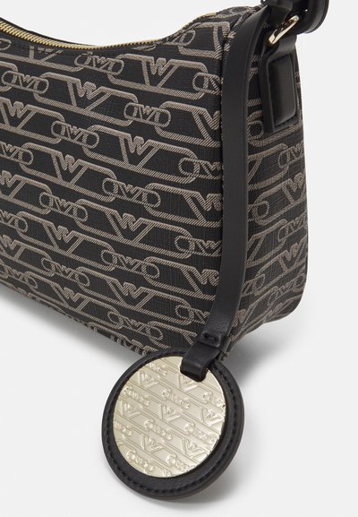 Borsa a mano in tessuto nero con un motivo a logo ripetuto, hardware in tono oro e un portachiavi rotondo con dettagli in rilievo.