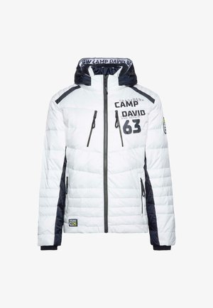 Witte gewatteerde jas met marineblauwe accenten, hoge kraag, ritszakken en bedrukt tekstdetail. Voorzien van een capuchon en elastische manchetten.