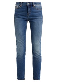 Kapeet farkut keskipitkä sinisessä denimissä kevyellä kulutuksella, joissa on klassinen viisi-taskuinen malli ja kupariset niitit.