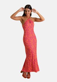 Vestido maxi de cuello halter en rosa y naranja con patrones intrincados. Silueta ajustada, dobladillo acampanado y tejido texturizado.