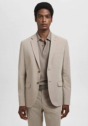Beige, skræddersyet jakkesæt med en struktureret blazer, hakkede klapper og to knapper. Matchet med en matchende polo t-shirt af glat stof.