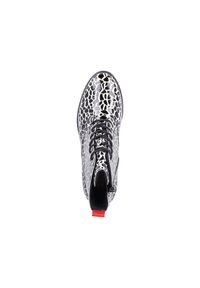 Bottine à motif noir et blanc avec une finition brillante, bout rond, lacets noirs et un accent rouge à l'arrière.