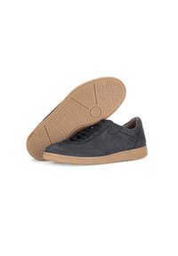 Sneaker in pelle grigia con accenti perforati, punta rotonda, lacci scuri e una suola in gomma color beige chiaro con un motivo testurizzato.