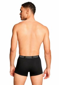 Zwarte boxershorts met een brede elastische tailleband met het "PUMA"-logo. Eenvoudig ontwerp met een aansluitende pasvorm en een gladde textuur.