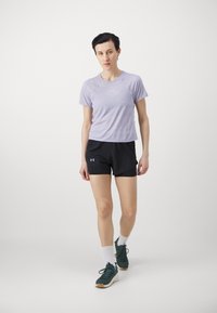 Violet trumpas rankovės sportinis marškinėliai derinami su juodomis šortais, su sportiniais batais ir baltais kojiniais. Paprastas, funkcionalus dizainas.