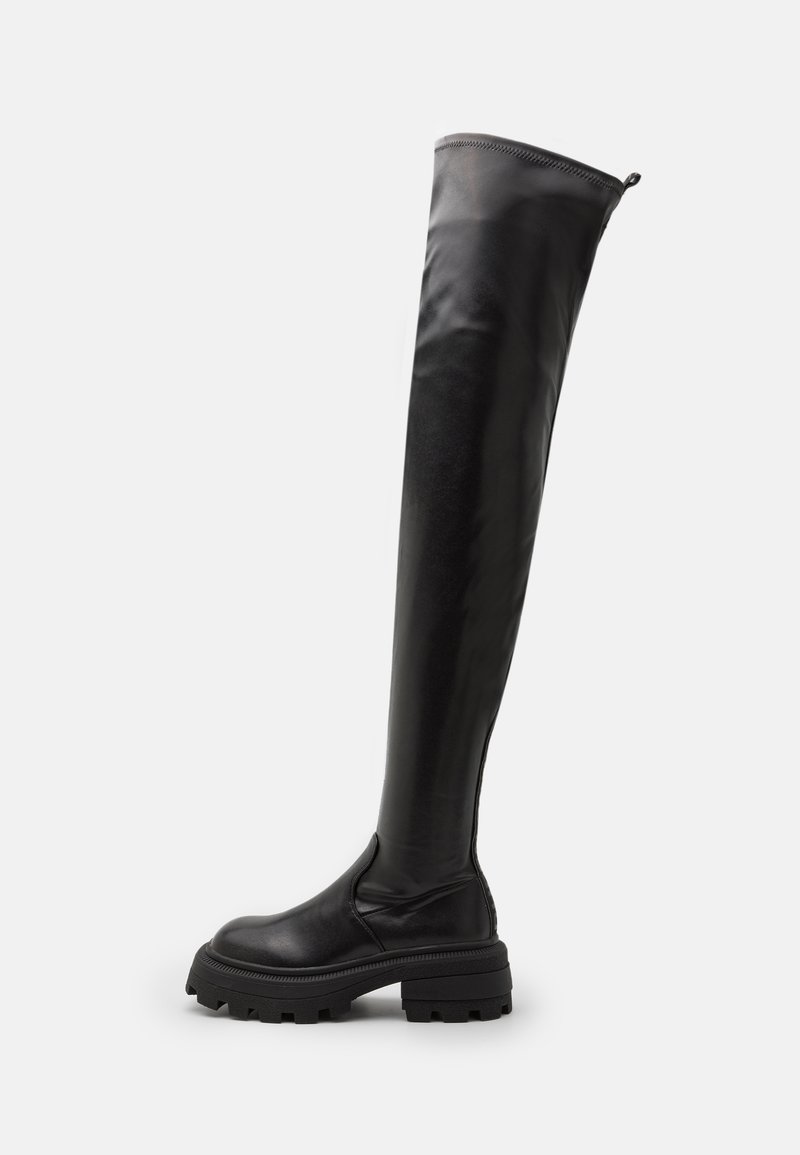 Botas de cuero negro hasta la rodilla con un diseño elegante, acabado texturizado, suela de goma gruesa y detalles de costura mínimos.