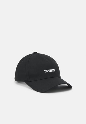 Schwarze Baseballkappe mit gebogenem Schirm und weißem Schriftzug "THE KOOPLES" mittig auf dem Vorderteil, dargestellt vor einem hellgrauen Hintergrund.