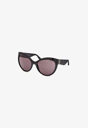 Ochelari de soare tip cat-eye cu un cadru lucios negru, lentile gradiente de culoare maro și brațe negre cu model, având accente cu logo-ul mărcii.