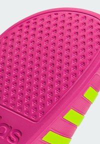 Pink textured sole with diamond patterns, highlighted with yellow accent stripes. Made from flexible rubber material.