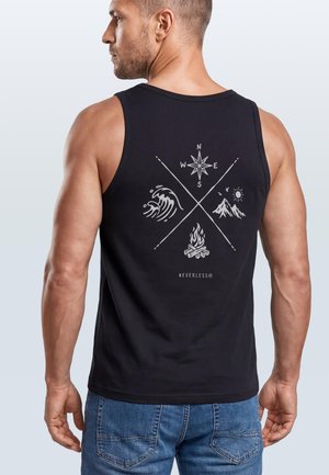 Mann trägt schwarzes ärmelloses Shirt mit Kompass-, Wellen-, Berg- und Lagerfeuer-Motiven, steht mit dem Rücken zum Betrachter.