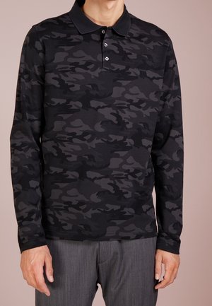 Koszulka polo z długim rękawem w czarny wzór moro, z kołnierzykiem, trzema guzikami i miękką fakturą. Odpowiednia do codziennego noszenia.