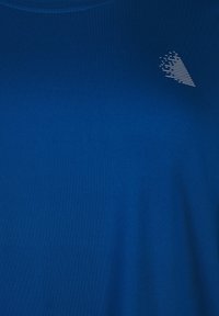 Blue T-shirt made of smooth fabric, featuring a round neckline and a small, abstract white graphic on the upper left side.