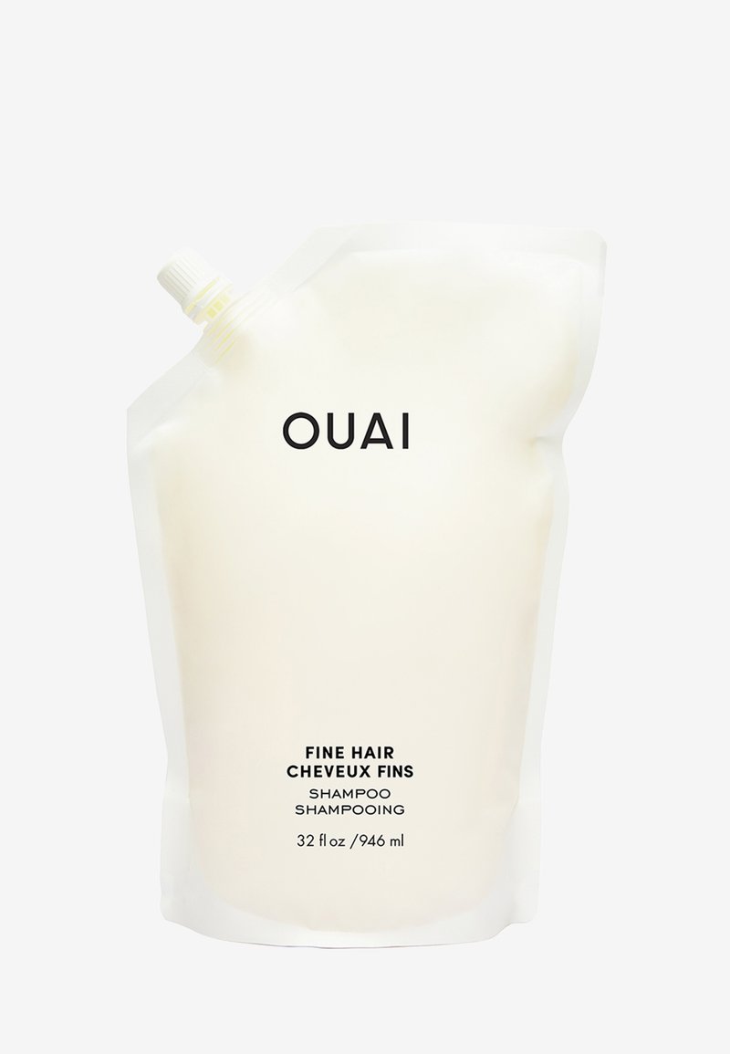 Szampon do cienkich włosów OUAI w elastycznej białej torebce z zakrętką, oznaczony czarnym tekstem. Zawiera 32 fl oz (946 ml) produktu.