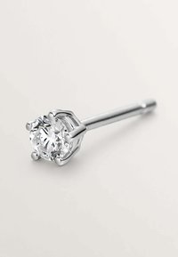 Pendiente de diamante con corte redondo engastado en un marco de metal plateado de cuatro garras, sobre un fondo liso.