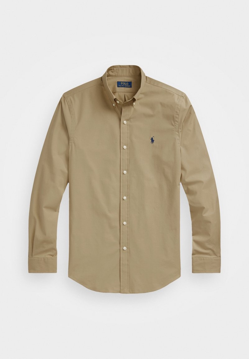 Beige långärmad skjorta med knappar och button-down krage samt en liten mörk broderad logotyp på vänster bröst.