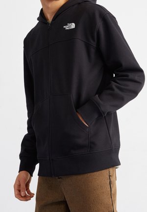 Felpa con cappuccio nera con zip, realizzata in tessuto morbido, con tasca a marsupio, polsini a coste e piccolo logo sul petto.