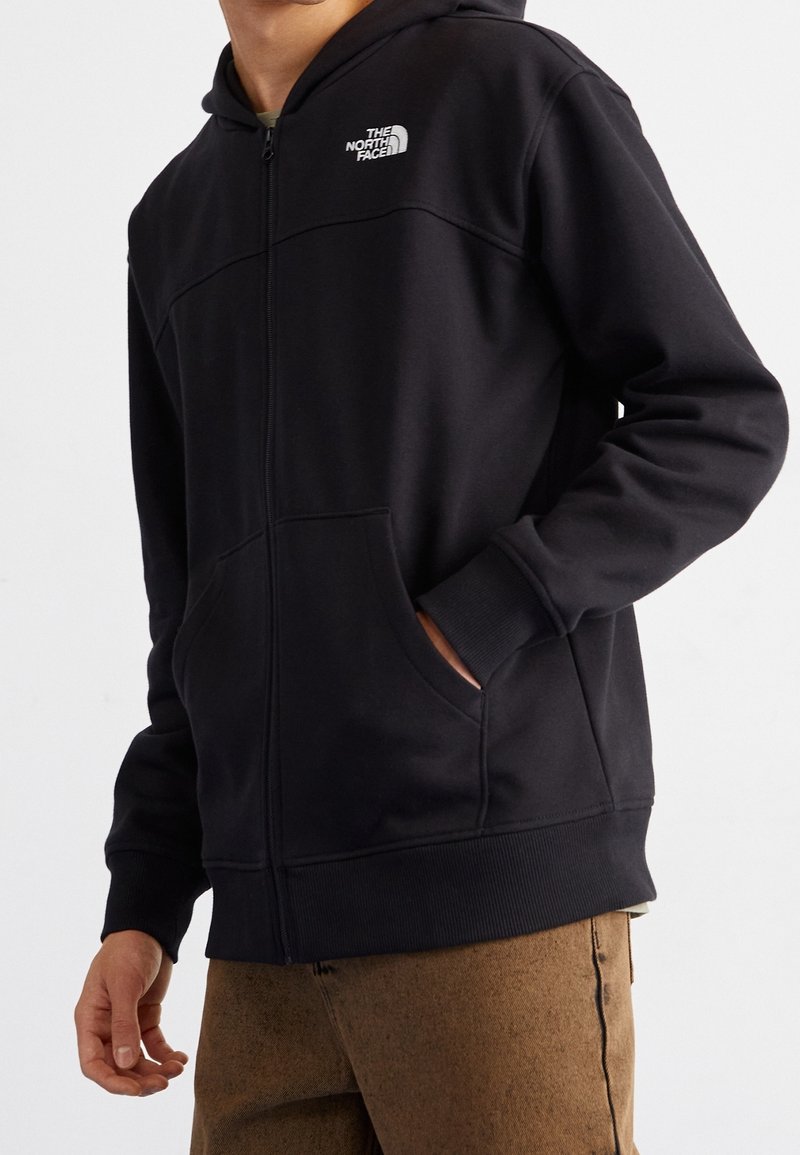 Felpa con cappuccio nera con zip, realizzata in tessuto morbido, con tasca a marsupio, polsini a coste e piccolo logo sul petto.