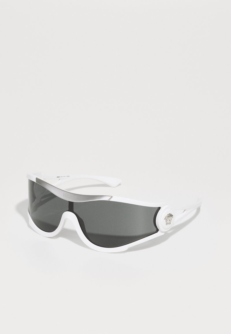 White sunglasses with a curved design, dark grey lenses, and a metallic accent on the side. Smooth texture, sporty style.