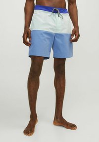 Blåa och mintgröna badshorts med dragsko i midjan, med en färgblockdesign och en mjuk textur.