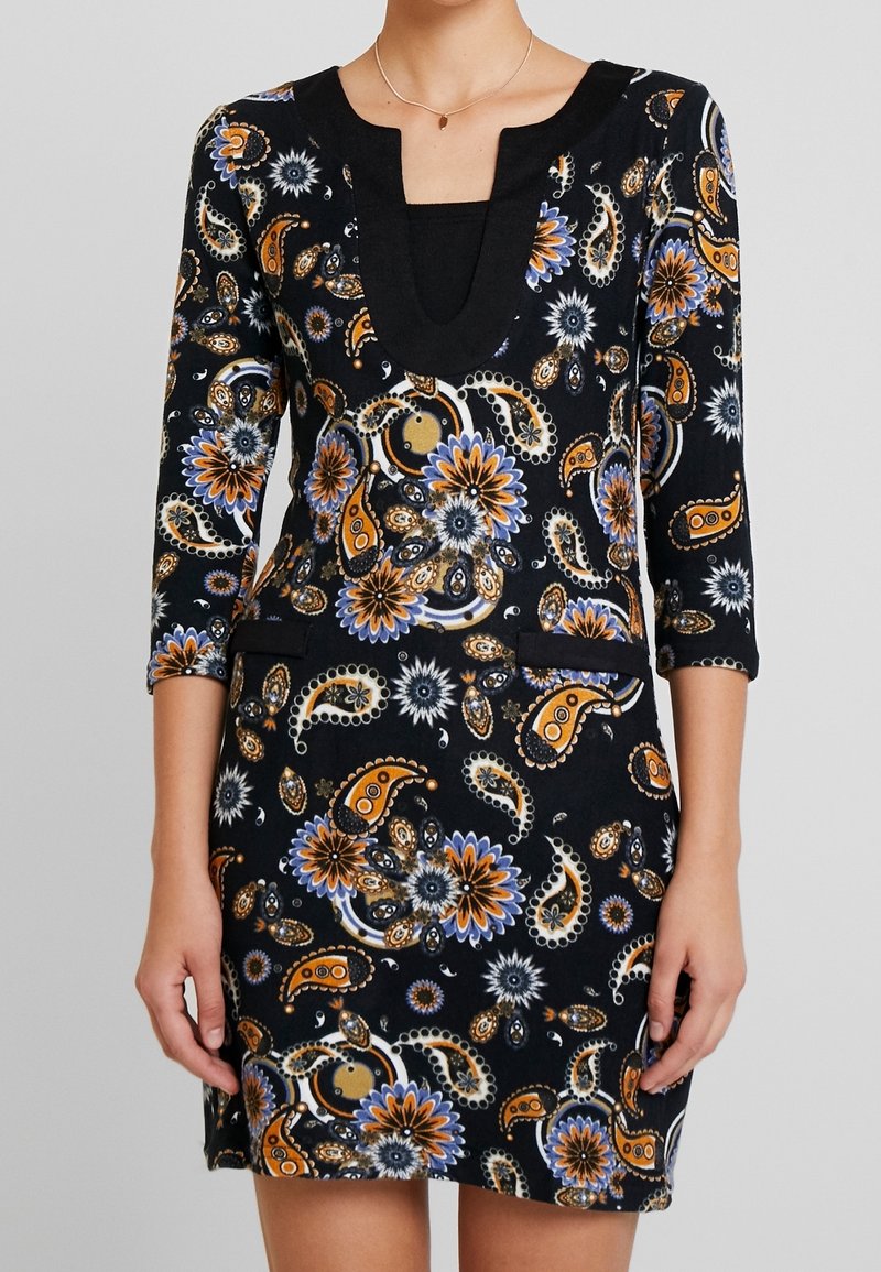 Robe noire à motifs paisley avec des manches trois-quarts, décolleté en cœur, ornée de motifs floraux orange, bleu et blanc ; comprend deux poches latérales.